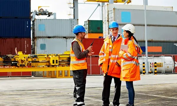 Group of logistics workers talking in a container terminal